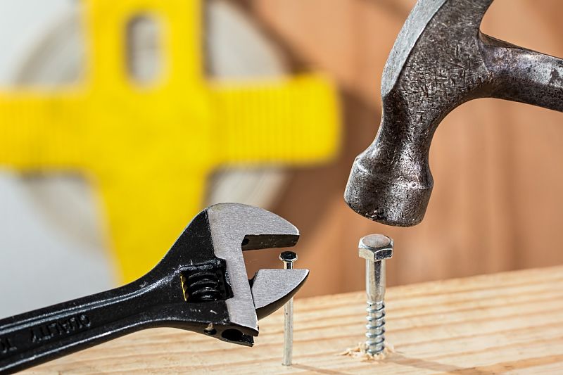 photo of hammer hitting a screw and wrench turning a nail
