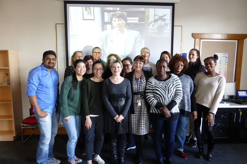 university of tasmania's senior lecturer christine handley with her postgraduate nursing students and a large photo of christine padesky as the backdrop